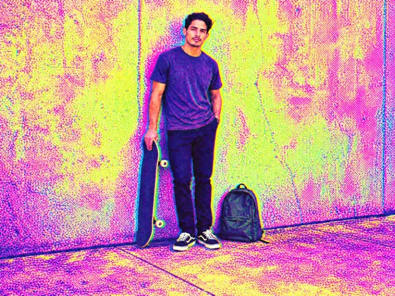 An adult holding a skateboard beside a closed backpack in the Fluorescent Dither style