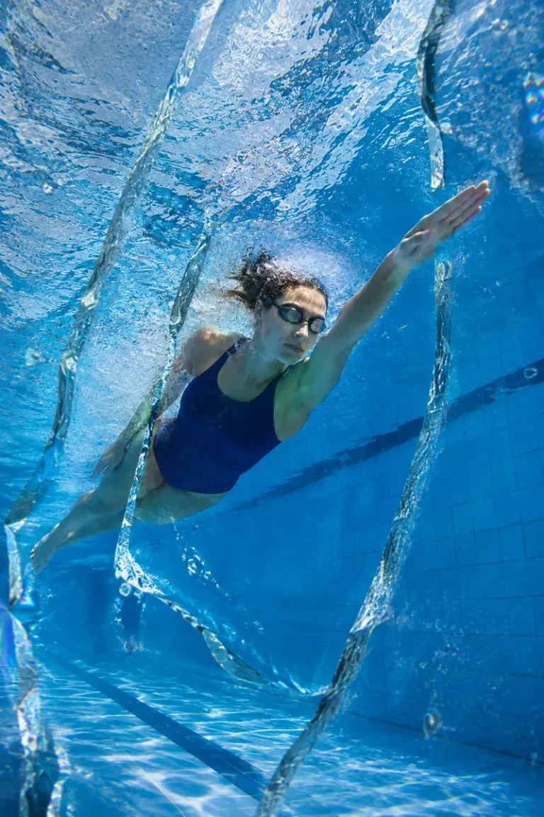 Swimmer moving through a tiled pool in the Glass Current style